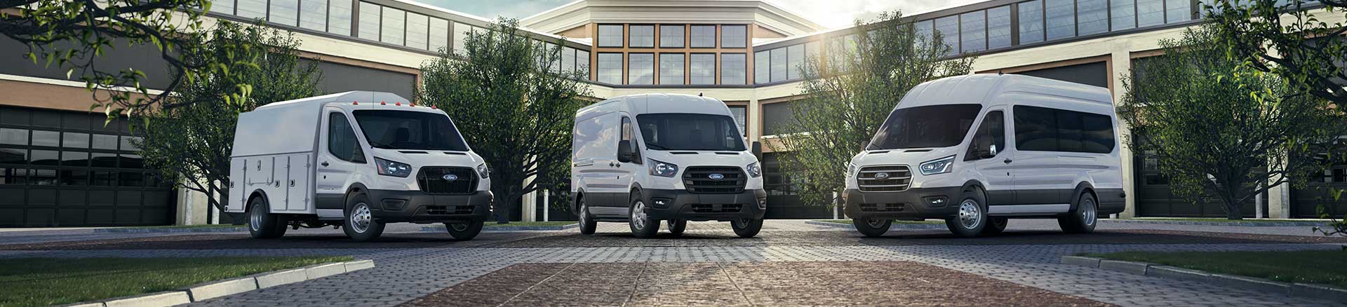 Three 2020 Ford Transit vans in a business courtyard.